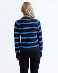 Person wearing a black and blue striped sweater on a white background