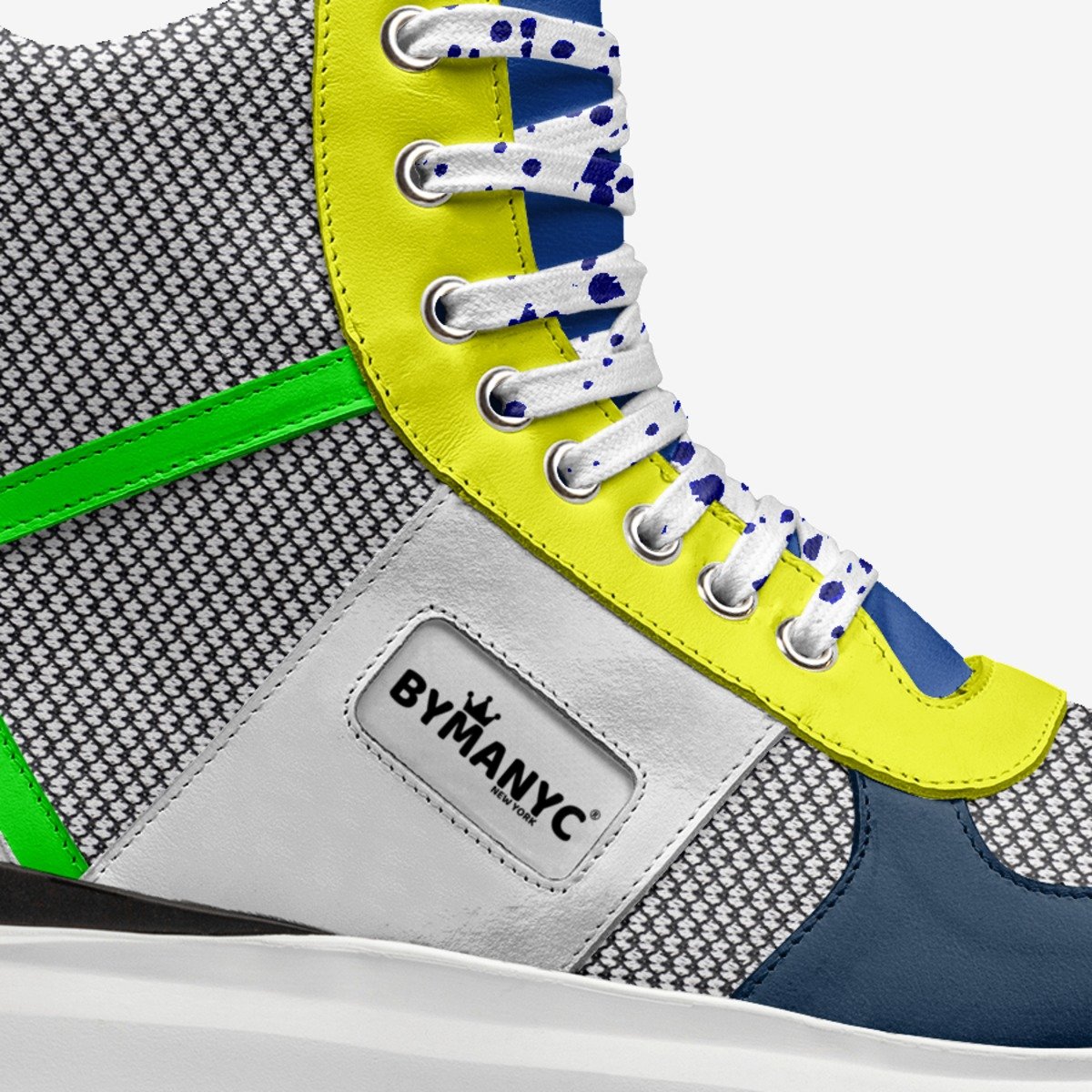 Close-up of a sneaker with colorful accents and 'BYMANYC' branding.