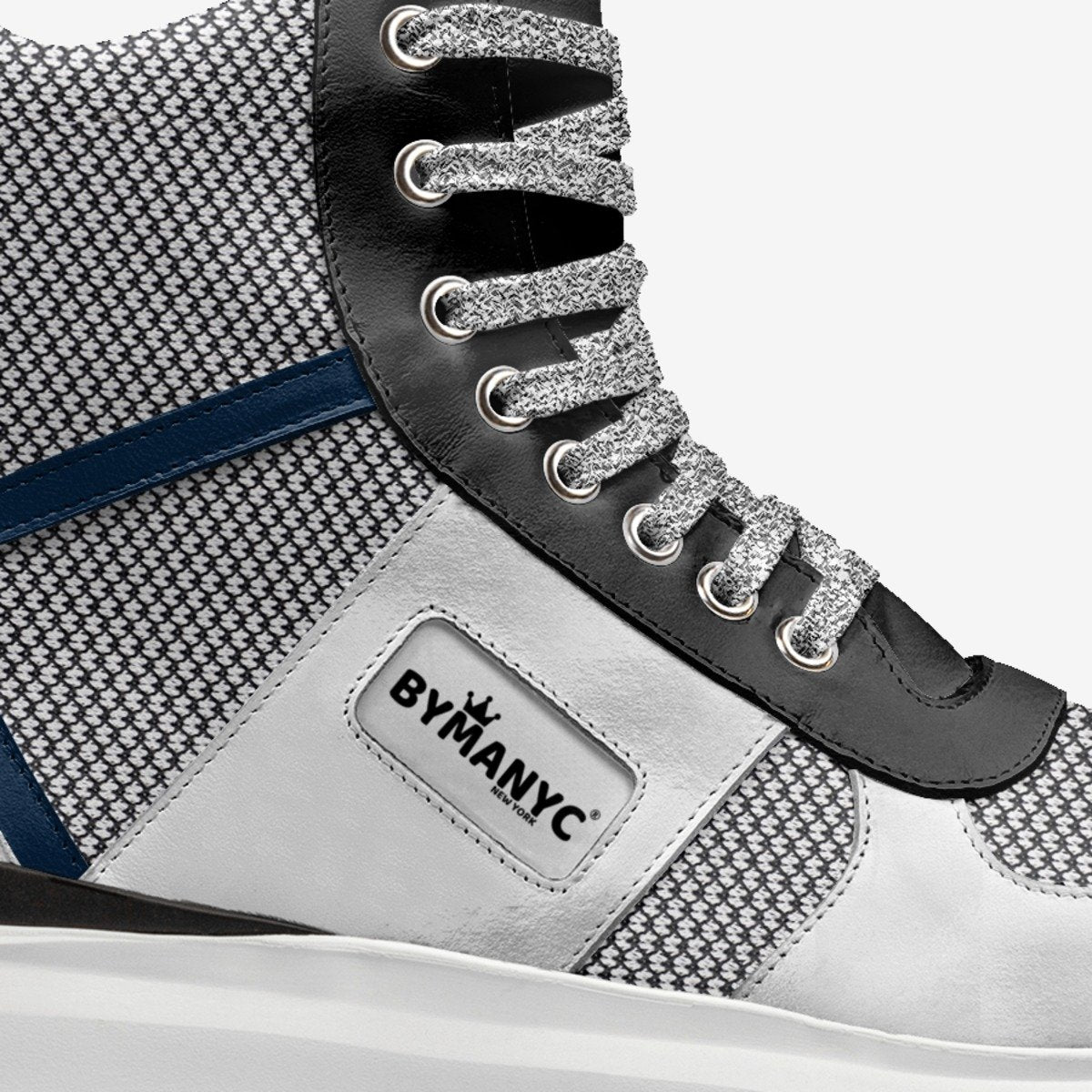 Close-up of a sneaker with 'BLYMANYC' branding on a white background