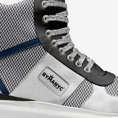 Close-up of a sneaker with 'BLYMANYC' branding on a white background