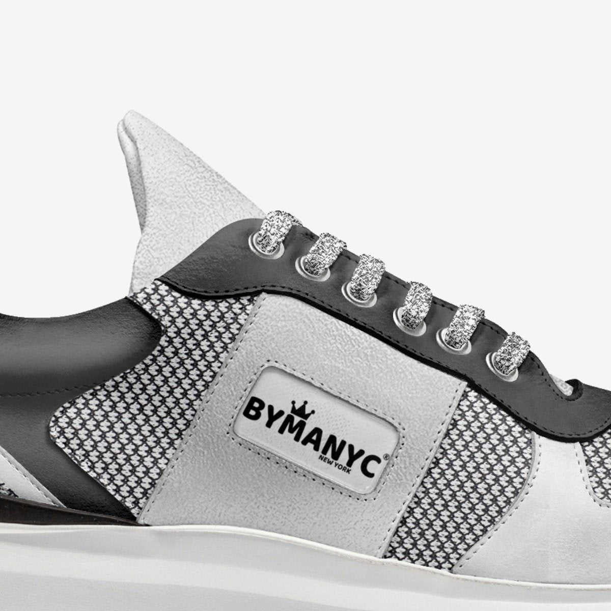 Gray and black sneaker with 'BY MANYC' branding on a white background