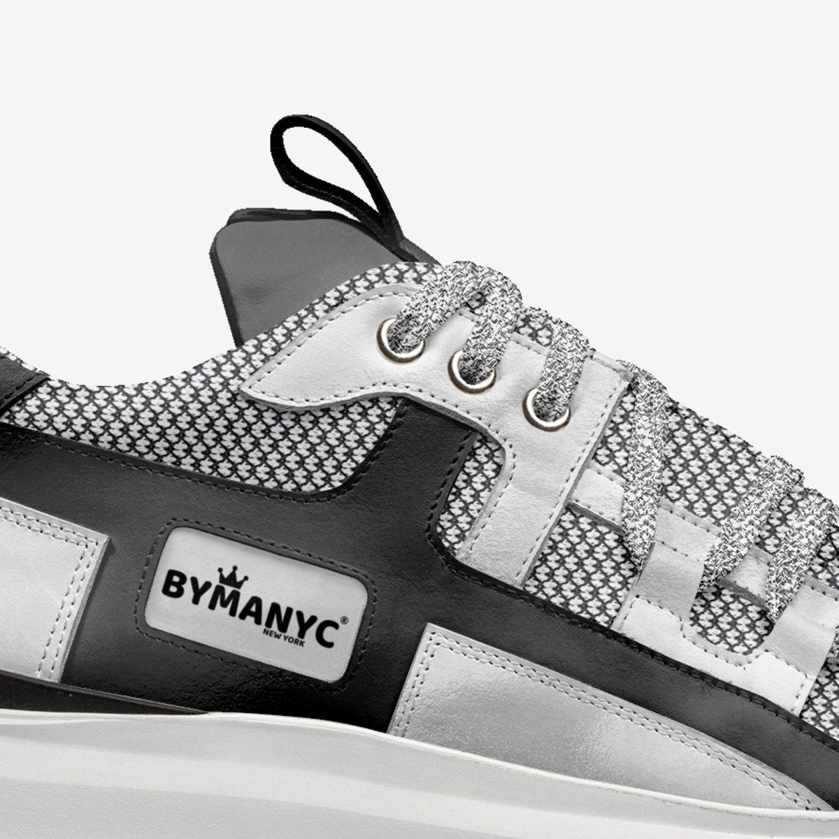 Black and white sneaker with 'BYMANYC' branding on a white background