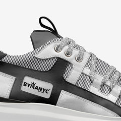 Black and white sneaker with 'BYMANYC' branding on a white background