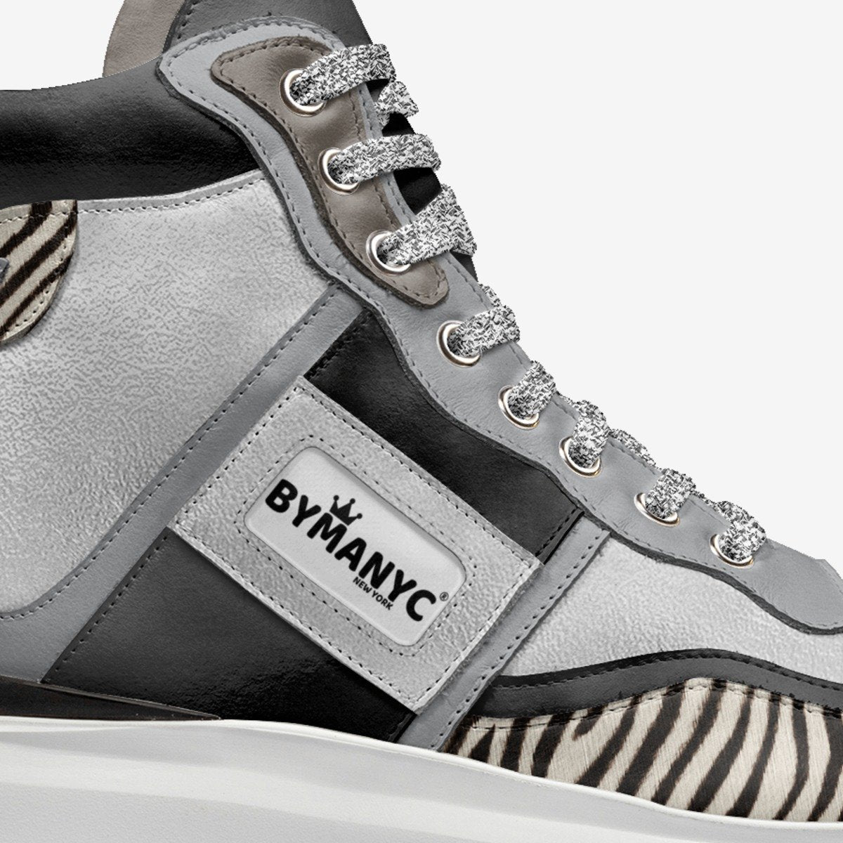 Gray and black sneaker with zebra pattern and rhinestone details, featuring the BYMANYC brand.