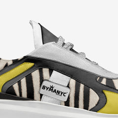 Sneaker with zebra pattern and yellow accents, featuring the BYMANYC brand logo.