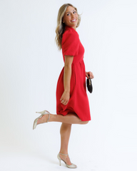 Woman wearing a red dress on a white background
