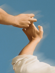 Two hands reaching towards each other against a blue sky