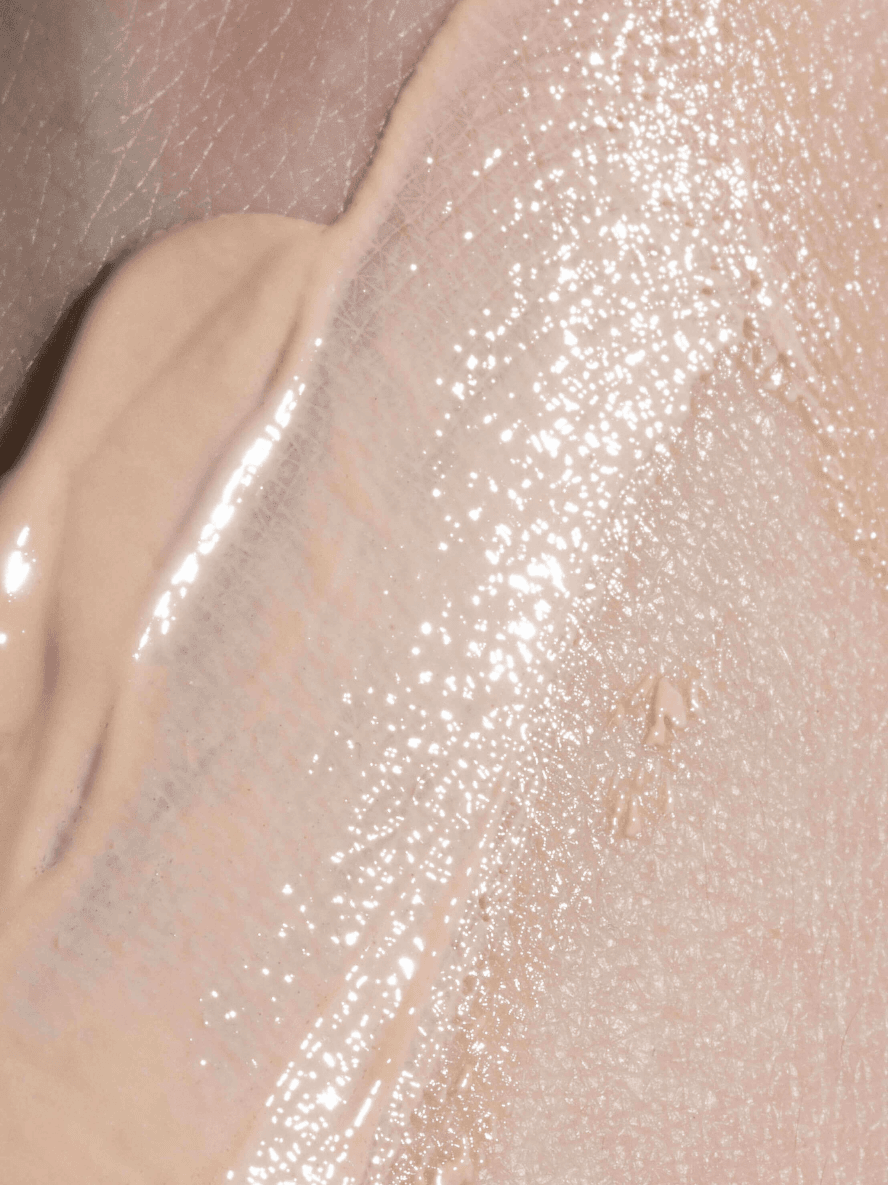 Close-up of a beige makeup product on a textured surface