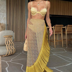 Woman wearing a yellow fringe skirt and top in an indoor setting.
