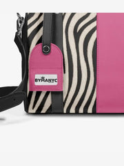 Handbag with zebra pattern and pink accent, featuring a BYMANYC tag.