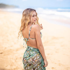 Woman in a floral dress standing on a beach