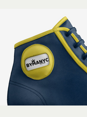 Blue shoe with yellow accents and a ByManyc logo on a light gray background