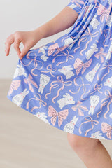 Child's dress with a pattern of bunnies and bows on a plain background
