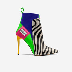 Colorful high-heeled shoe with zebra pattern and brand label on a white background