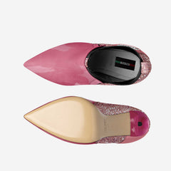 Pink pointed-toe shoe with a visible brand label on a white background