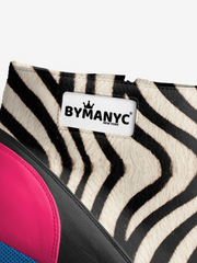 Close-up of a zebra-patterned product with a 'BY MANYC' label on a white background