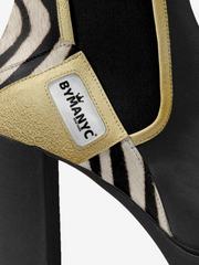 Zebra-patterned shoe with 'BYMANYC' label on a white background