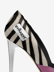 Zebra-striped high-heeled shoe with 'BYMANYC' label on a white background