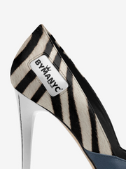 Zebra-striped high-heeled shoe with 'BYMANYC' label on a white background