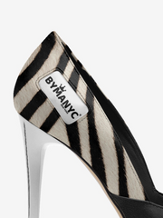 High-heeled shoe with zebra pattern and 'BYMANYC' label on a white background