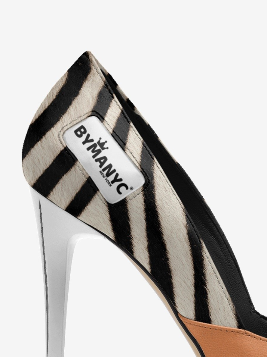 Zebra-striped high-heeled shoe with 'BYMANYC' label on a white background