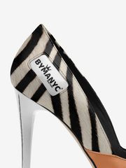 Zebra-striped high-heeled shoe with 'BYMANYC' label on a white background