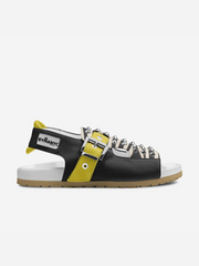 Black sandal with yellow accents and spikes on a white background