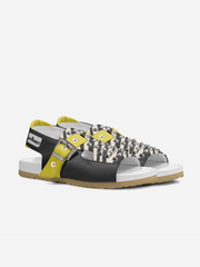 Black and yellow sandal with white sole on a light gray background