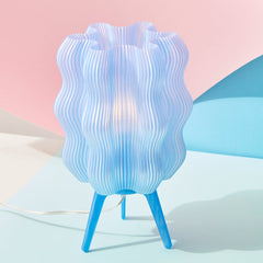 Blue textured table lamp on a light pink background