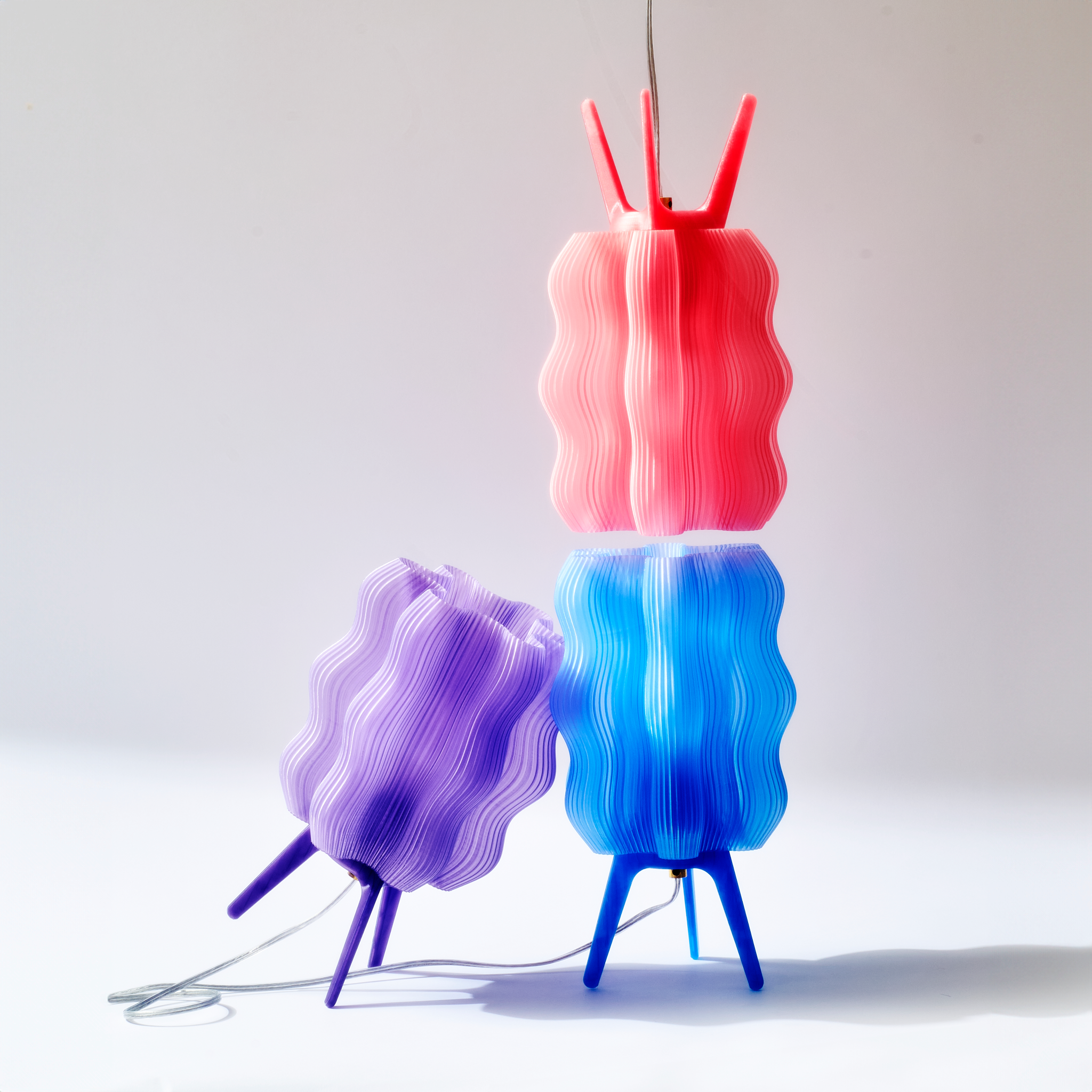 Three colorful floor lamps with wavy design on a white background
