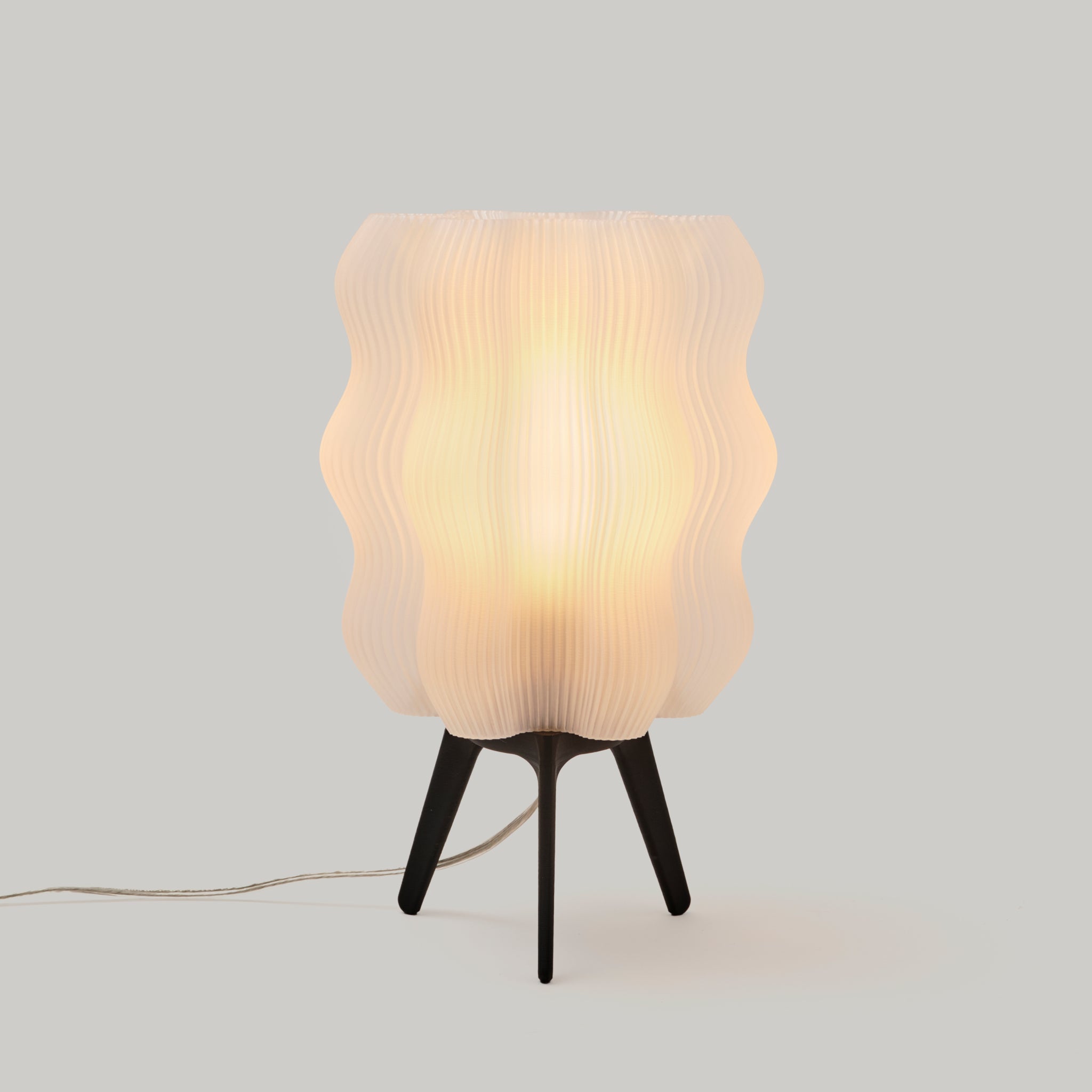Table lamp with wavy glass shade on a plain background