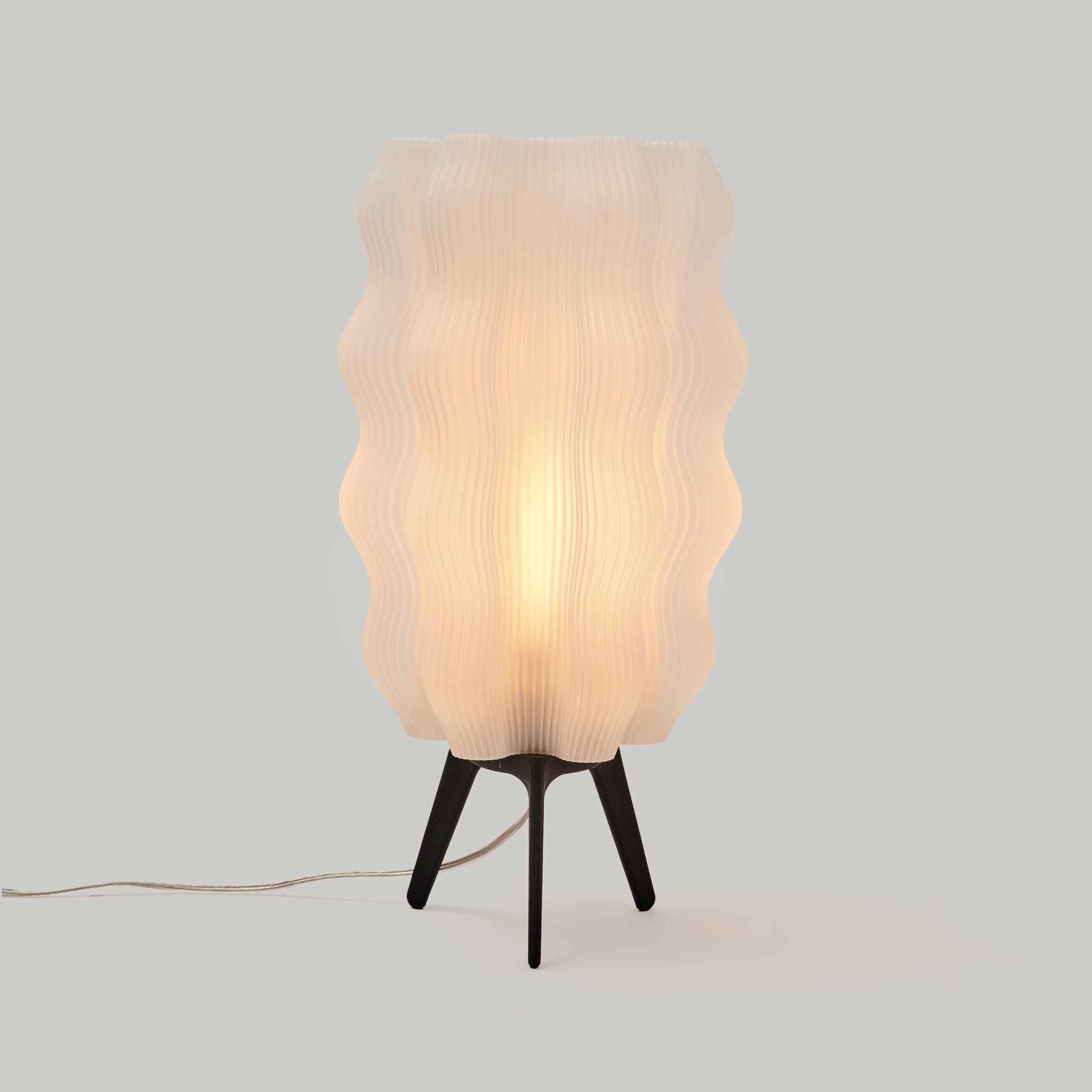 Table lamp with wavy glass shade on a plain background