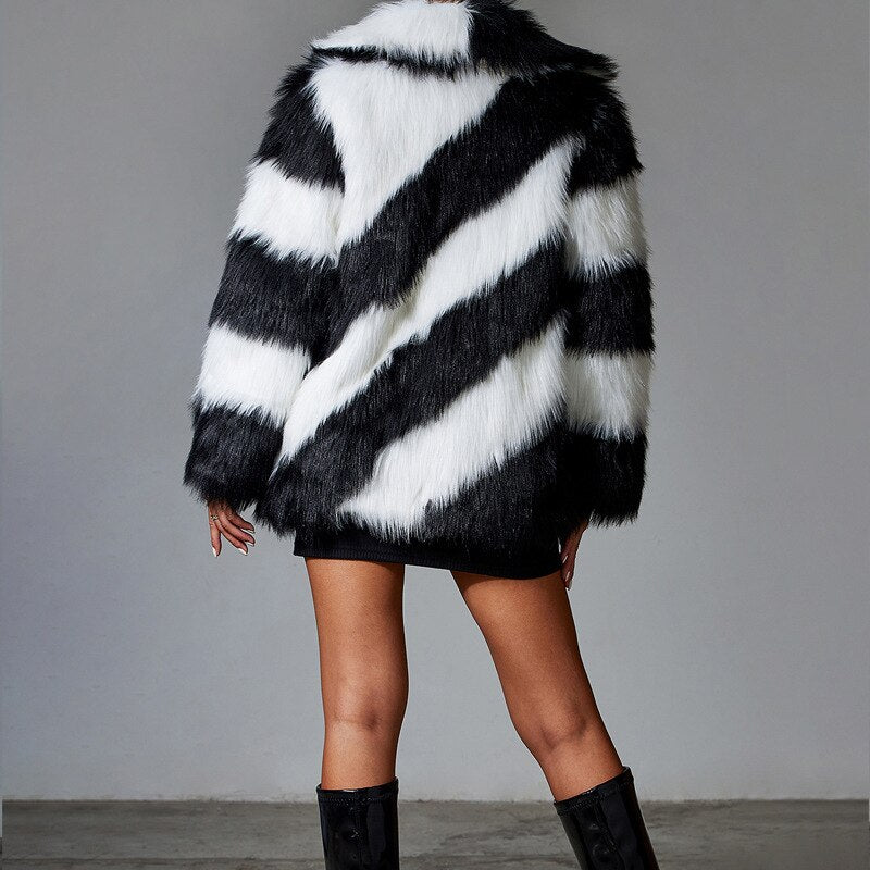 Black and white striped fur coat worn by a person on a gray background