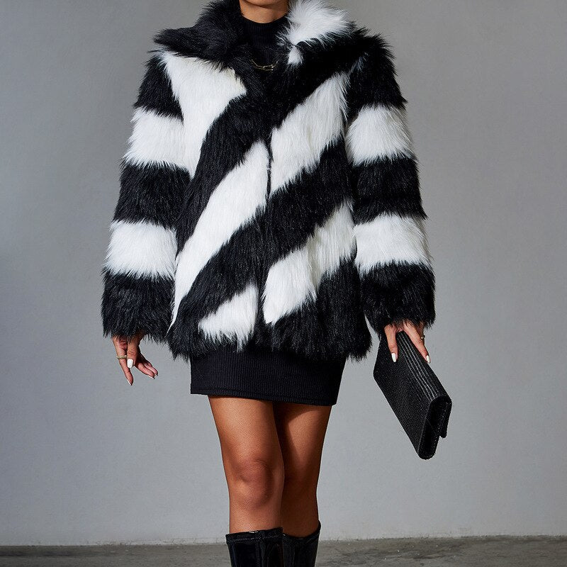 Person wearing a black and white striped fur coat against a gray background