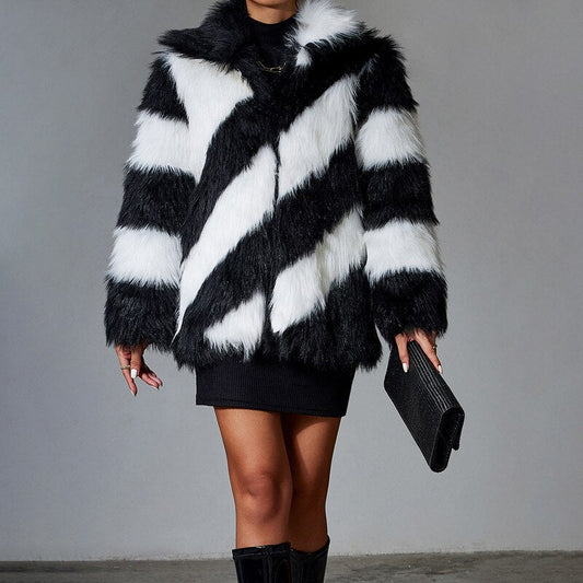Person wearing a black and white striped fur coat against a gray background