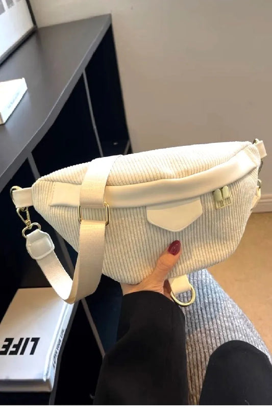 Person holding a white textured bag in an indoor setting