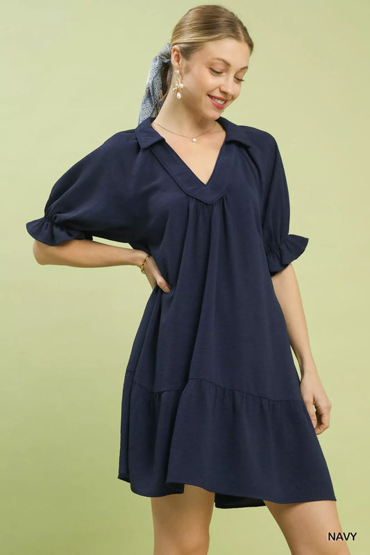 Woman wearing a navy dress on a light green background