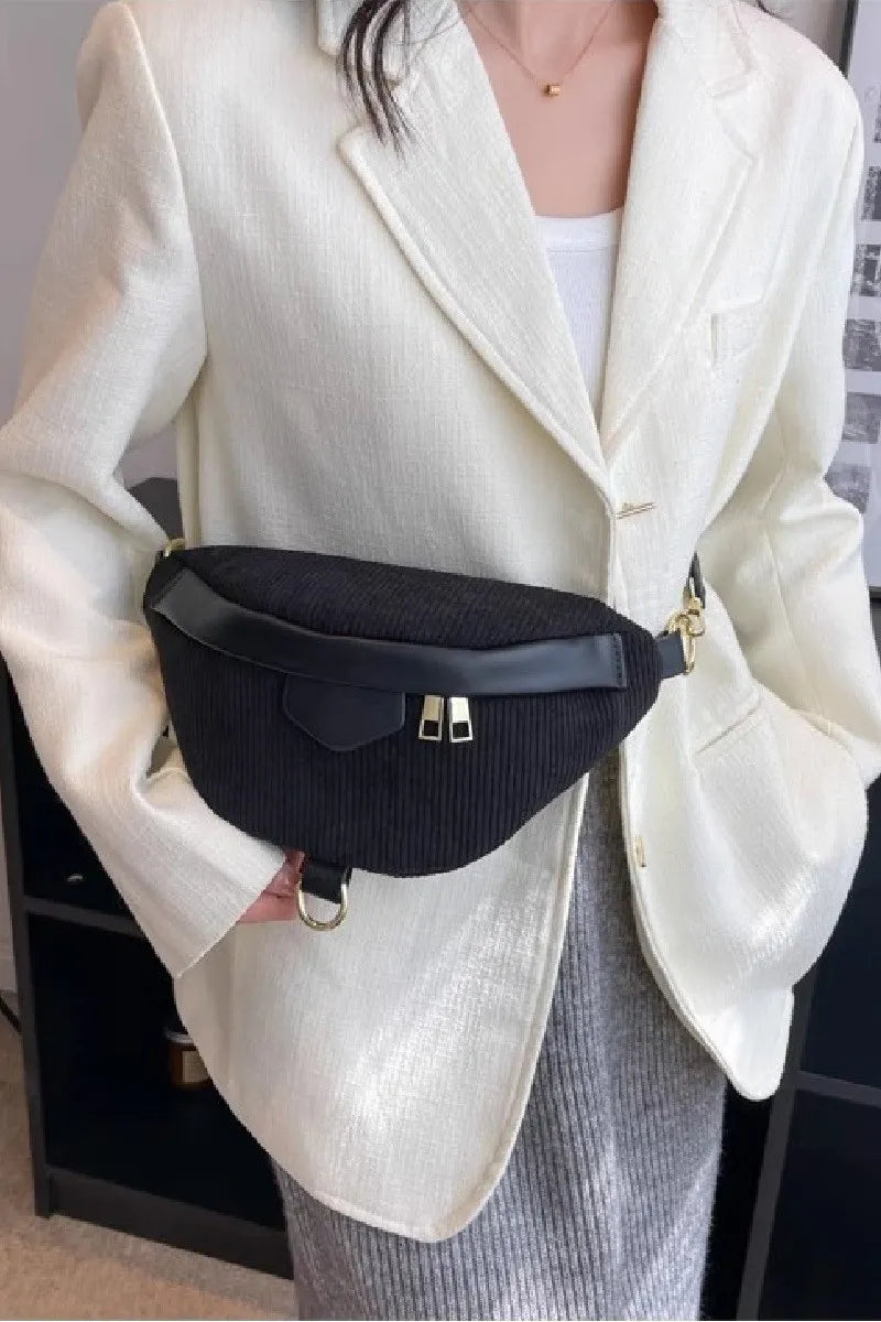 Person wearing a black waist bag with a neutral background