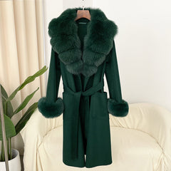 Green coat with fur collar and cuffs on a hanger against a white background