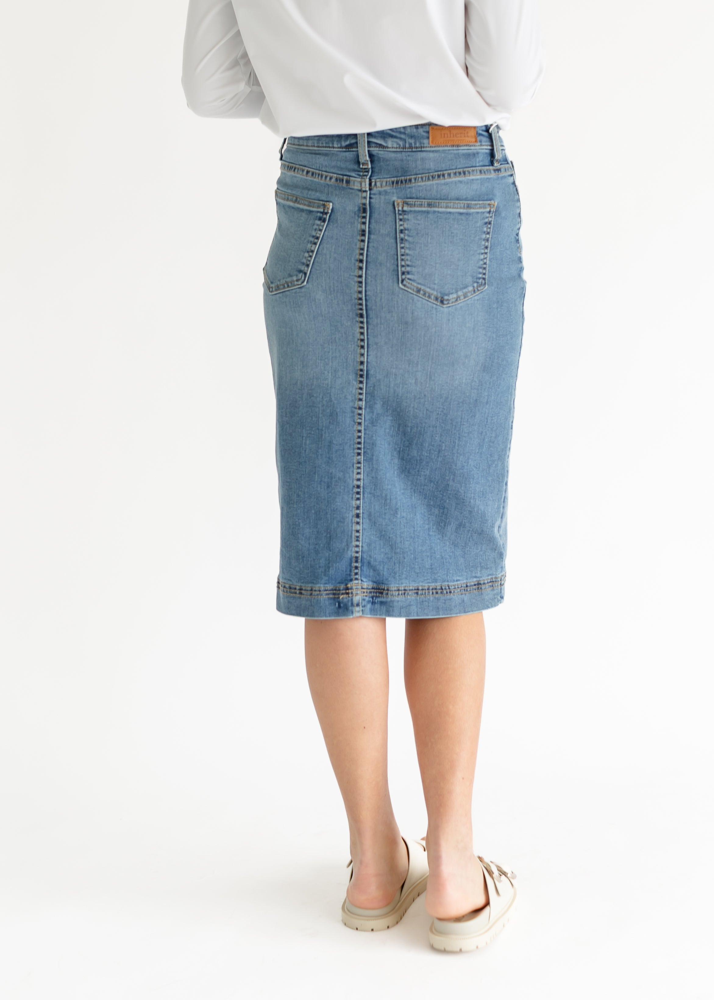 Light blue denim skirt worn by a person on a white background