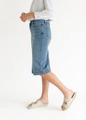 Person wearing light blue denim shorts on a white background