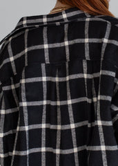Black and white checkered shirt worn by a person with a neutral background