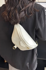 Person wearing a beige sling bag over one shoulder indoors.