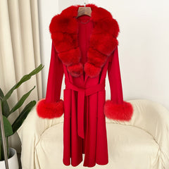 Red coat with fur trim on a hanger against a white curtain background