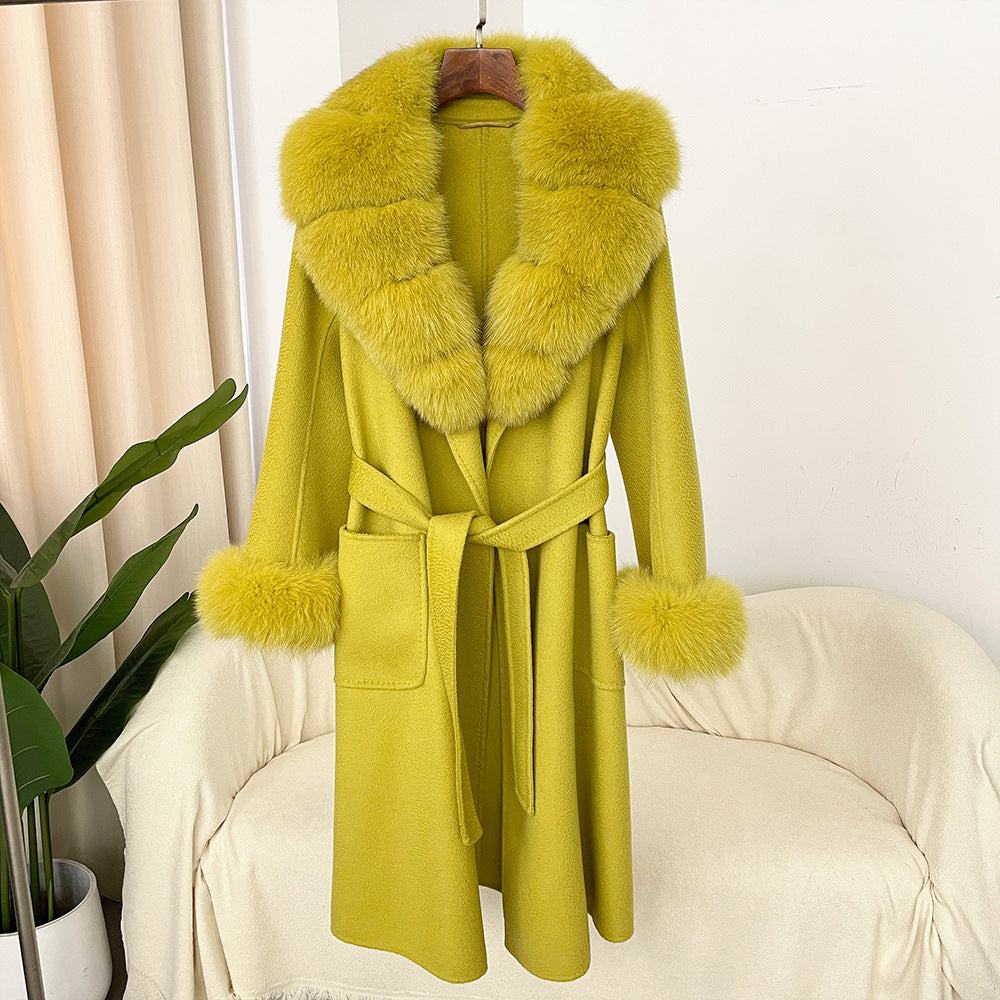 Yellow coat with fur collar on a chair against a white wall