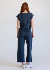 Person wearing a navy blue outfit with wide-leg pants on a plain background