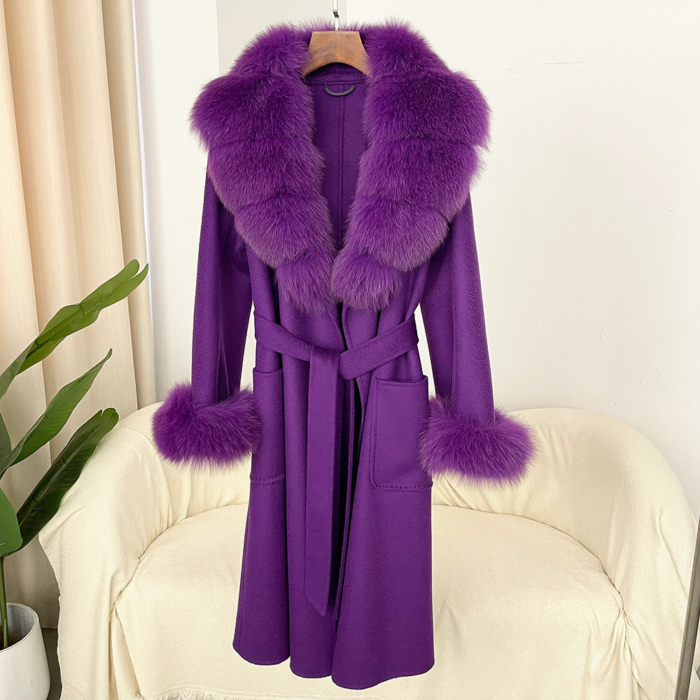 Purple coat with fur trim on a chair against a white background