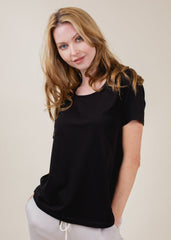 Woman wearing a black t-shirt against a beige background