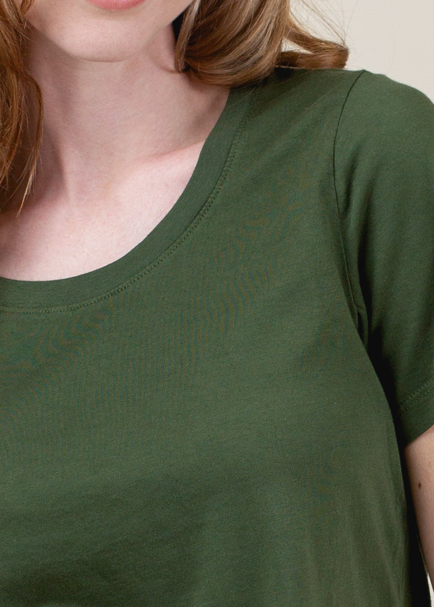 Green t-shirt worn by a person with a neutral background