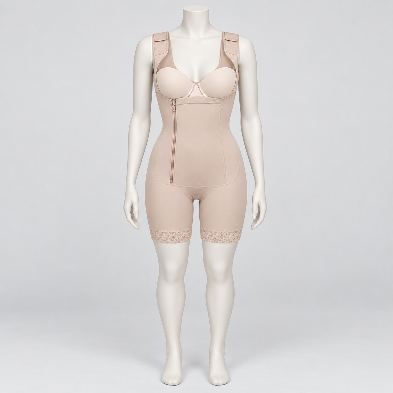 A beige full-body compression shapewear suit displayed on a female mannequin against a light gray studio background. The garment includes underwire cups, a front zipper, seamless shaping, and lace trim at the thighs.